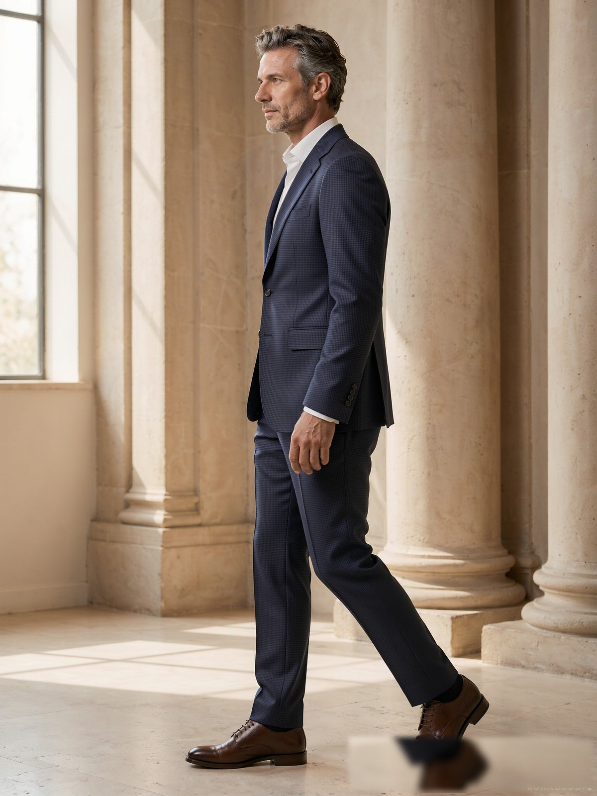 Mature model wearing a tailored navy birdseye Drago wool two-piece suit - side view