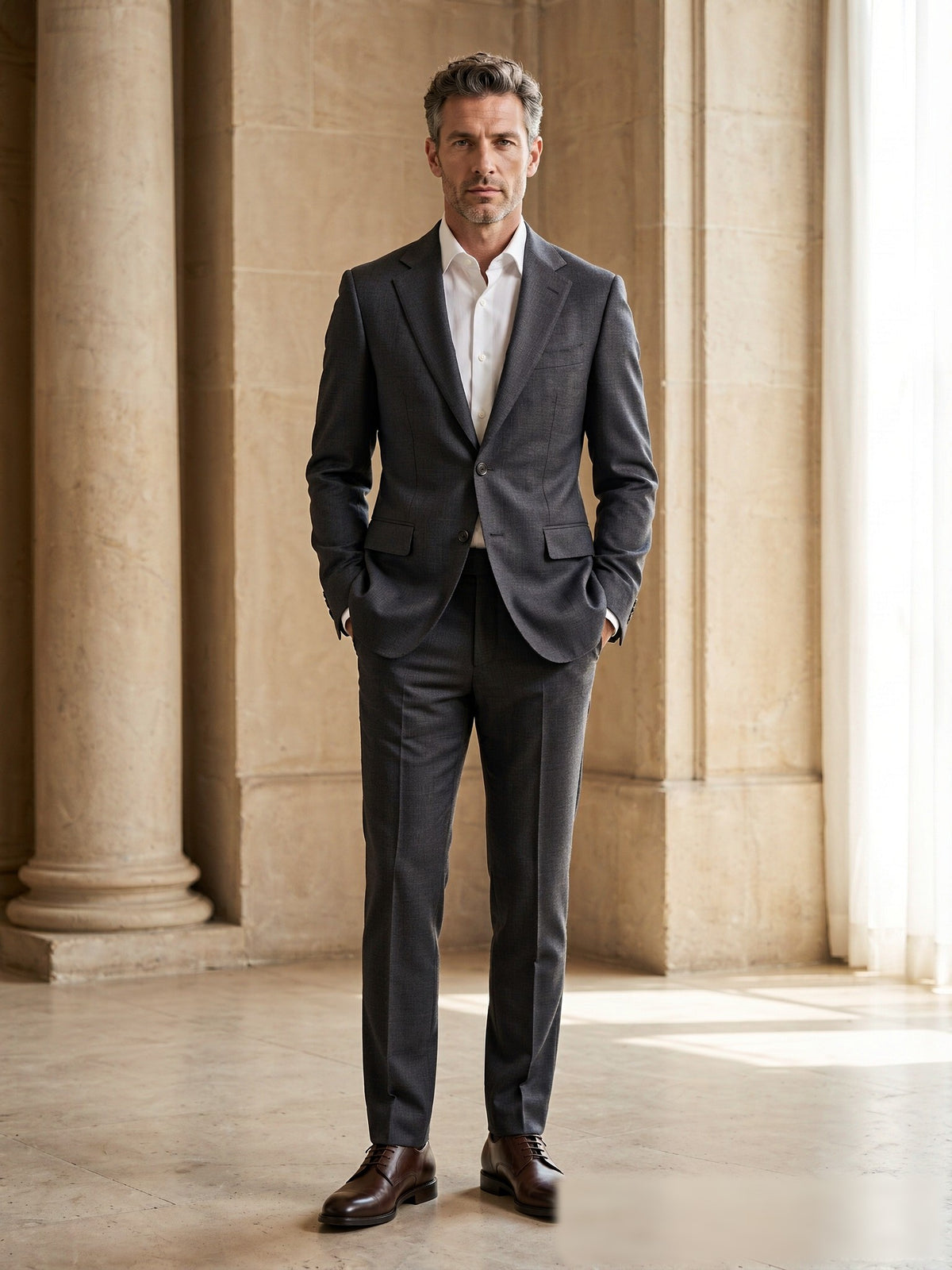 Mature model wearing a tailored charcoal grey Drago wool two-piece suit - front view