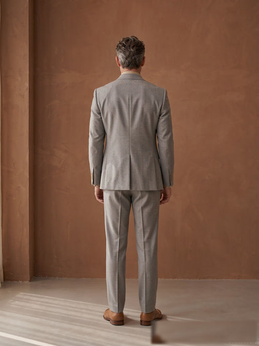 Mature model wearing a tailored grey Guabello wool double-breasted suit - back view