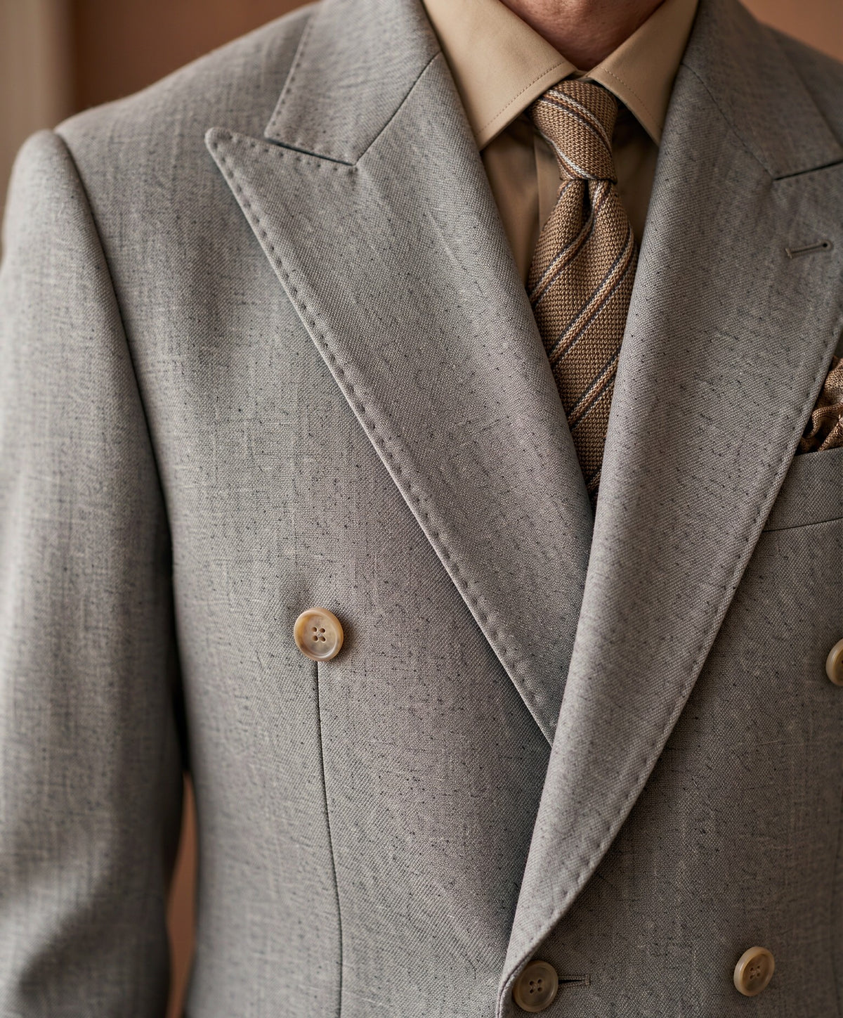 Close-up detail of grey Guabello wool suiting cloth - lapel, button and fabric weave