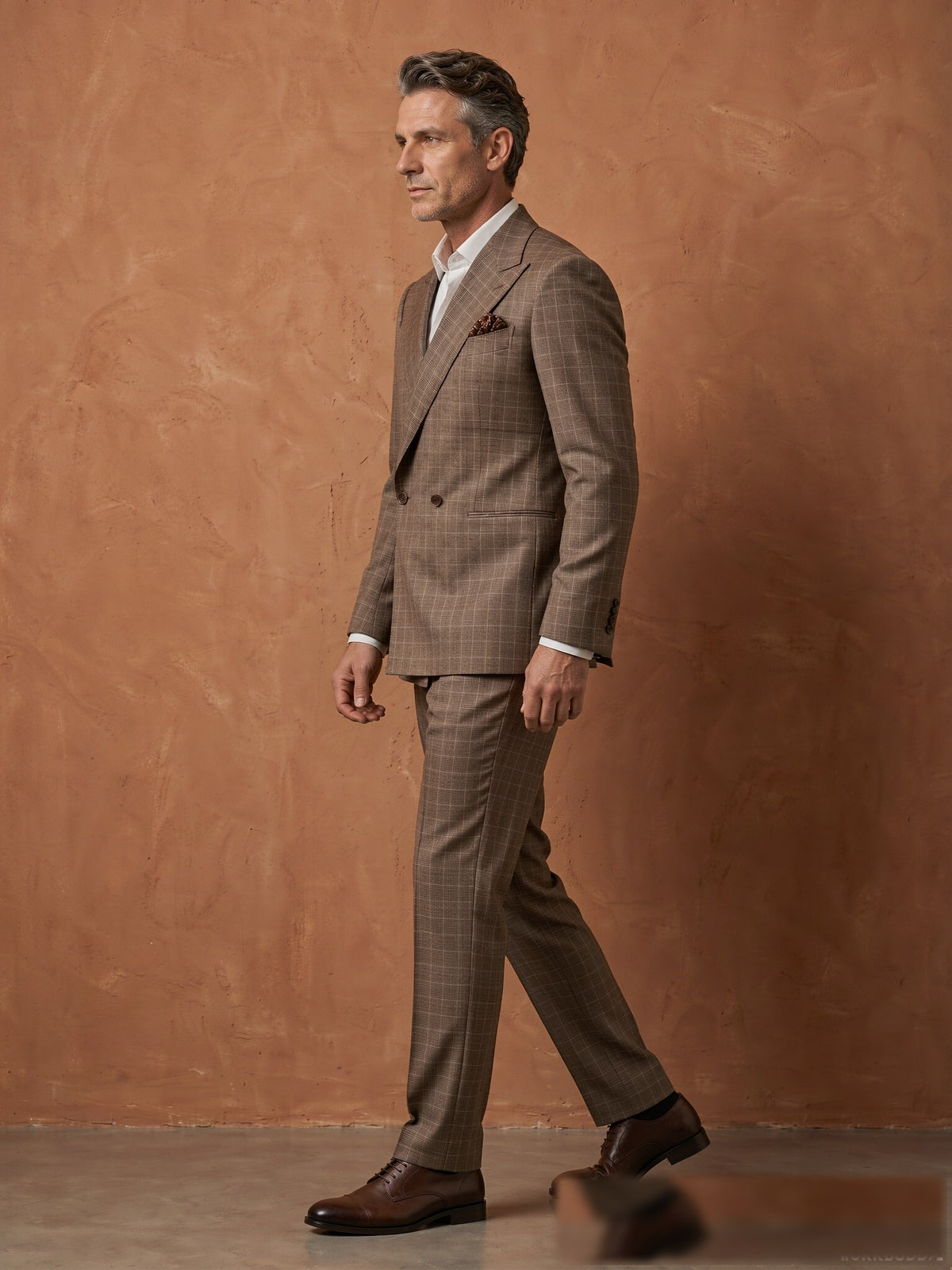 Mature model wearing a tailored brown plaid Guabello wool double-breasted suit - side view