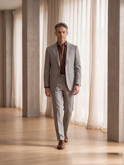 Mature model wearing a tailored light-grey VBC wool two-piece suit with brown shirt - front view