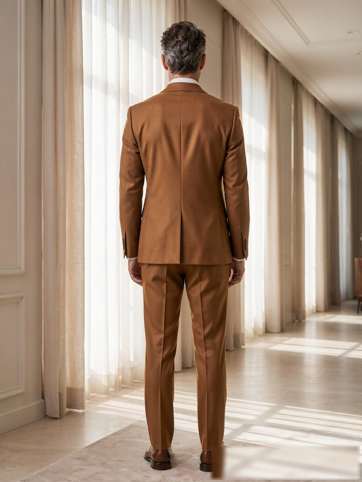 Mature model wearing a tailored warm beige VBC wool two-piece suit - back view